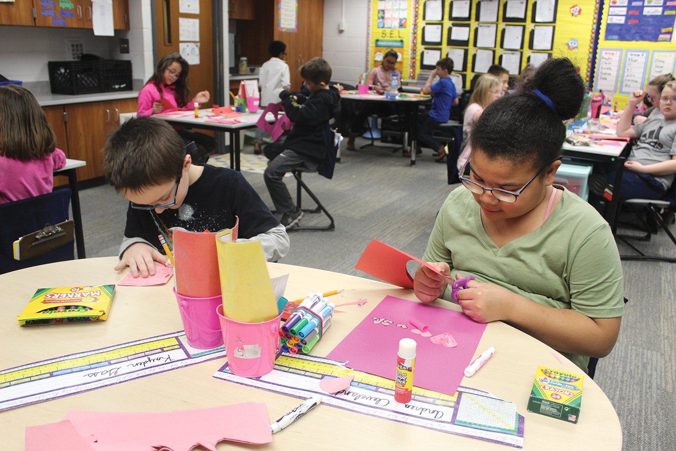 Nicholson third graders Kayden Gass, left, and Andrea Cleveland work together to make Valentine